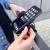 Wozinsky WBHBK3 w użyciu — dłonie wkładają smartfon do uchwytu na kierownicy hulajnogi