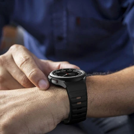 Galaxy Watch z czarnym paskiem Silicone Line na nadgarstku – zbliżenie
