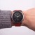 Garmin Fenix z czerwonym paskiem Silicone na nadgarstku mężczyzny w swetrze