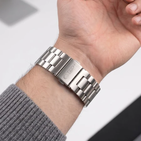 Srebrna bransoleta Stainless od strony zapięcia na nadgarstku – rękaw szarego swetra