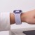Apple Watch z fioletowym (Periwinkle) paskiem NylonMag na nadgarstku kobiety w białej koszuli