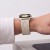 Apple Watch z tytanowym (Natural Titanium) paskiem NylonMag na nadgarstku kobiety w białej koszuli