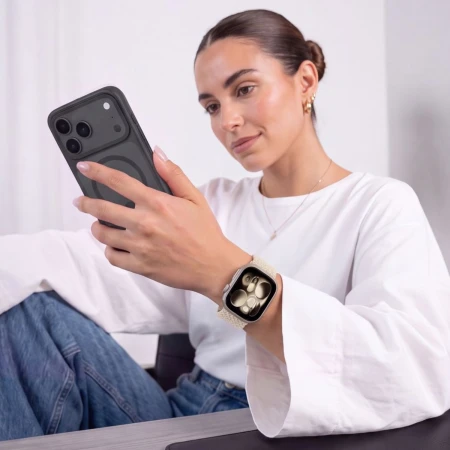 Kobieta z telefonem w dłoni – Apple Watch z tytanowym (Natural Titanium) paskiem NylonMag na nadgarstku