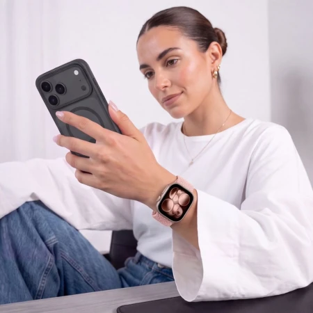 Kobieta z telefonem w dłoni – Apple Watch z różowym (Dusty Rose) paskiem NylonMag na nadgarstku
