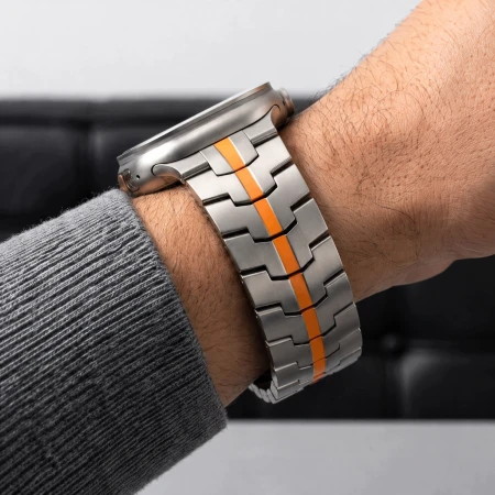 Zbliżenie bransolety Stainless Titanium/Orange na nadgarstku – stalowe ogniwa z pomarańczowym pasem