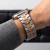 Zbliżenie bransolety Stainless Titanium/Orange na nadgarstku – stalowe ogniwa z pomarańczowym pasem