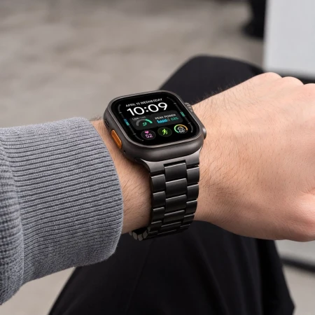 Czarna bransoleta Stainless z Apple Watch na nadgarstku mężczyzny w szarym swetrze