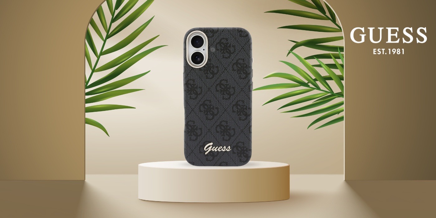 Czarne etui Guess 4G Script na iPhone 17 na beżowym podeście wśród liści palmy — zdjęcie producenta