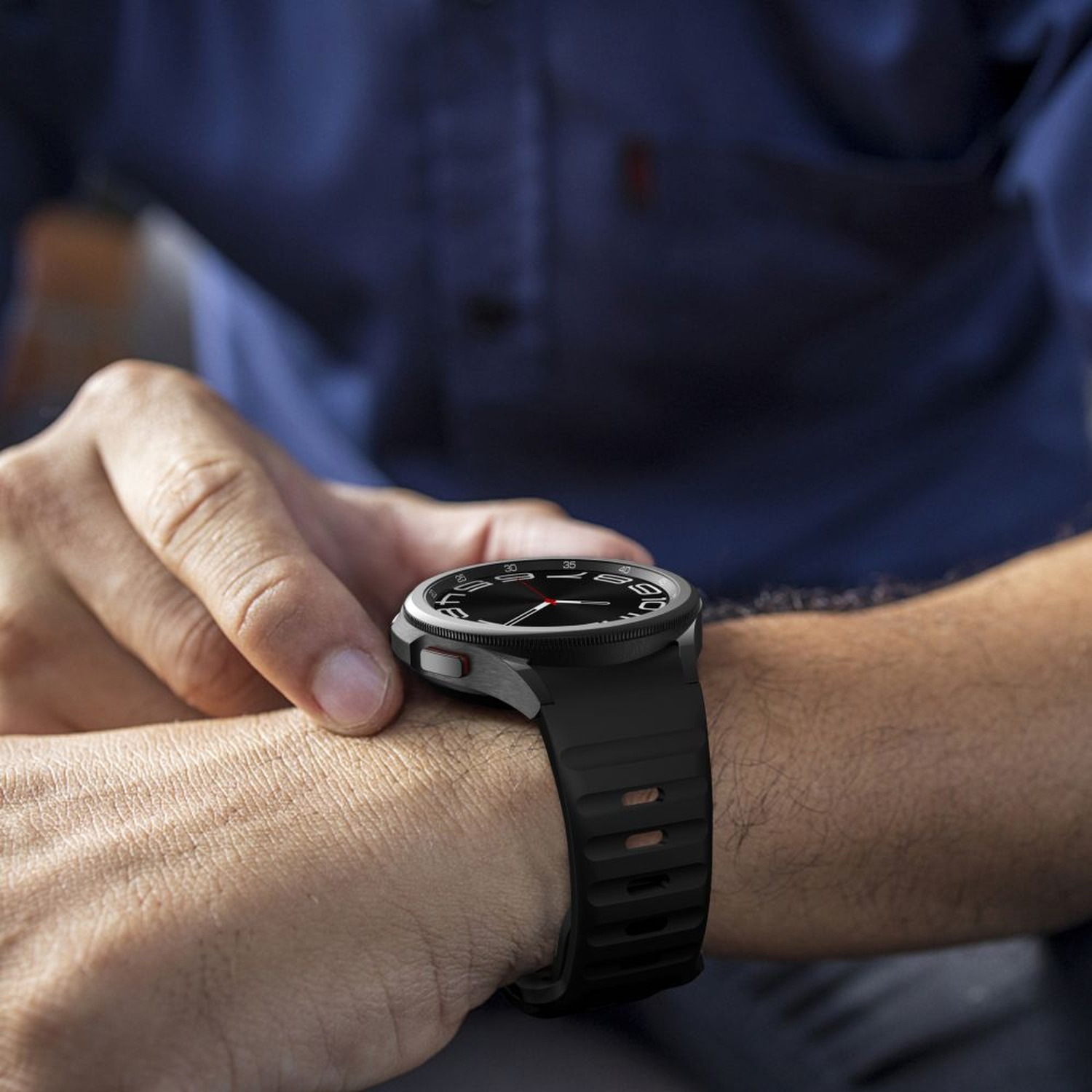 Galaxy Watch z czarnym paskiem Silicone Line na nadgarstku – zbliżenie