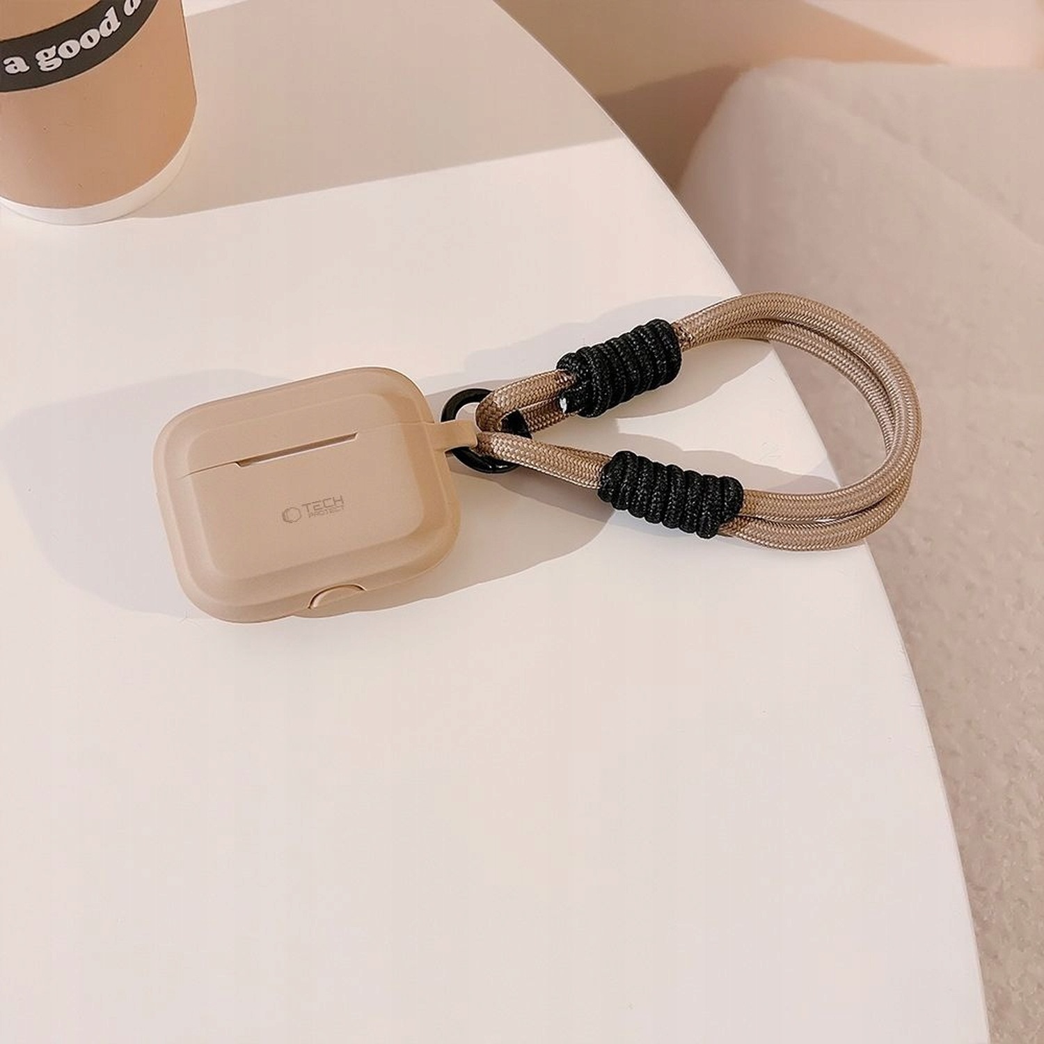 Etui Silicone Rope caffe latte ze smyczą na stoliku obok fotela