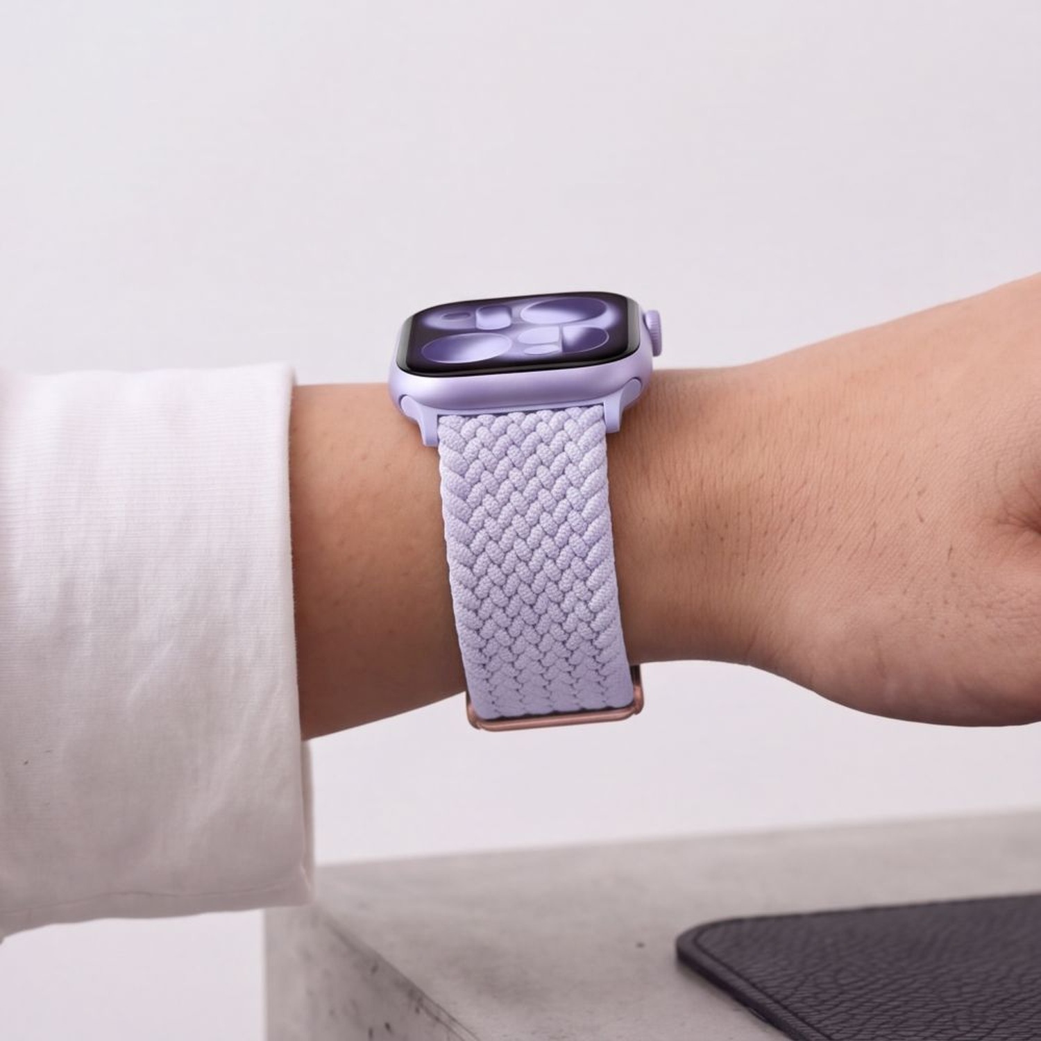 Apple Watch z fioletowym (Periwinkle) paskiem NylonMag na nadgarstku kobiety w białej koszuli