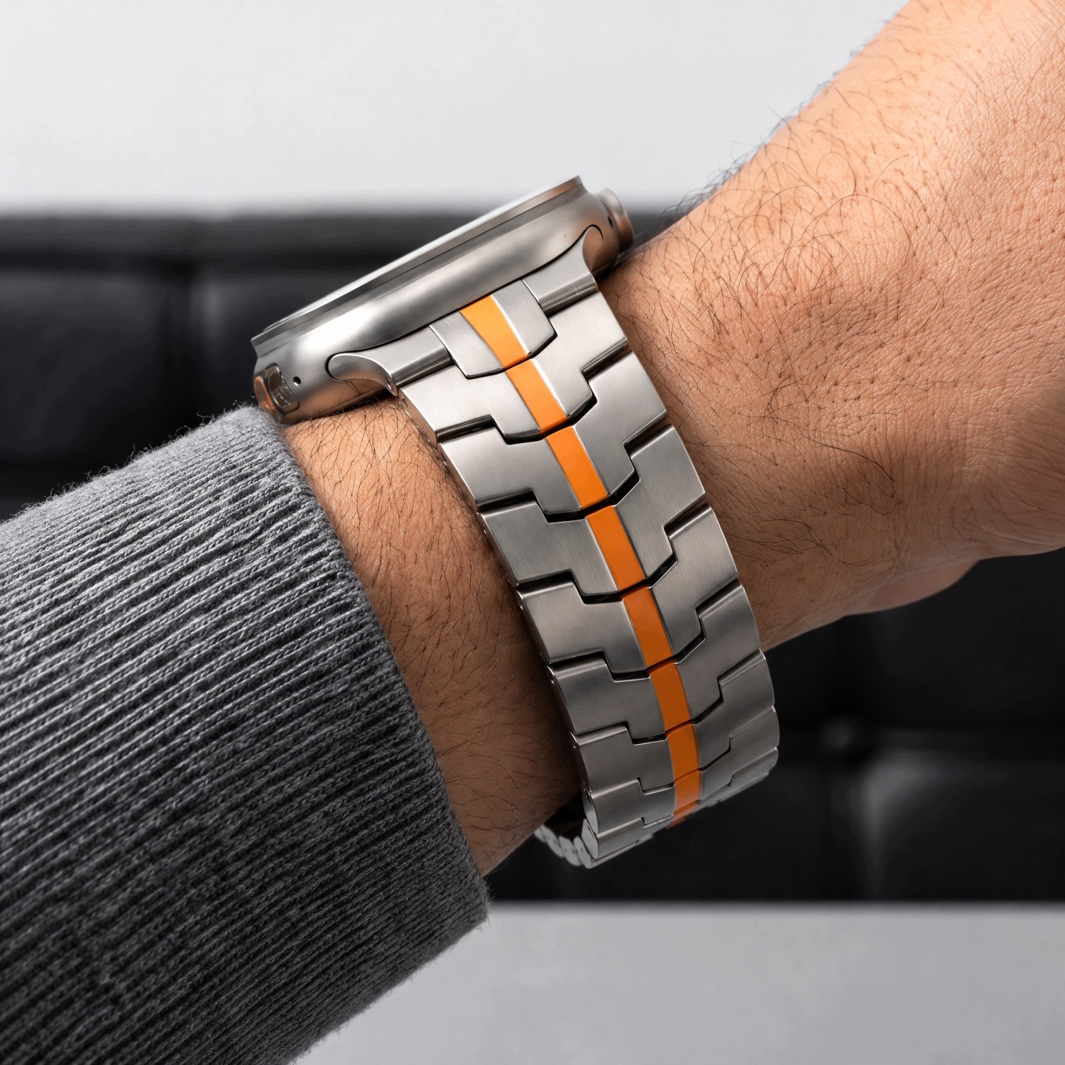 Zbliżenie bransolety Stainless Titanium/Orange na nadgarstku – stalowe ogniwa z pomarańczowym pasem