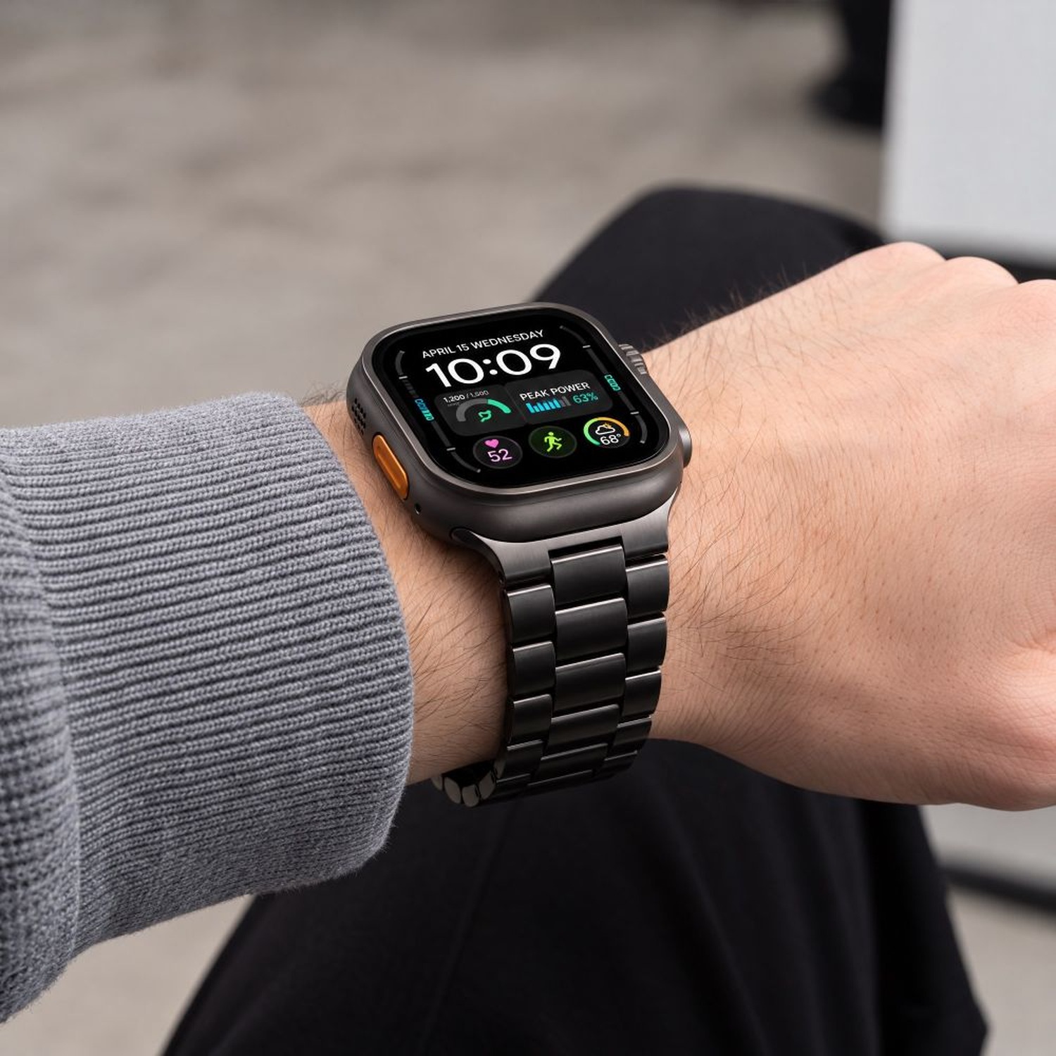 Czarna bransoleta Stainless z Apple Watch na nadgarstku mężczyzny w szarym swetrze